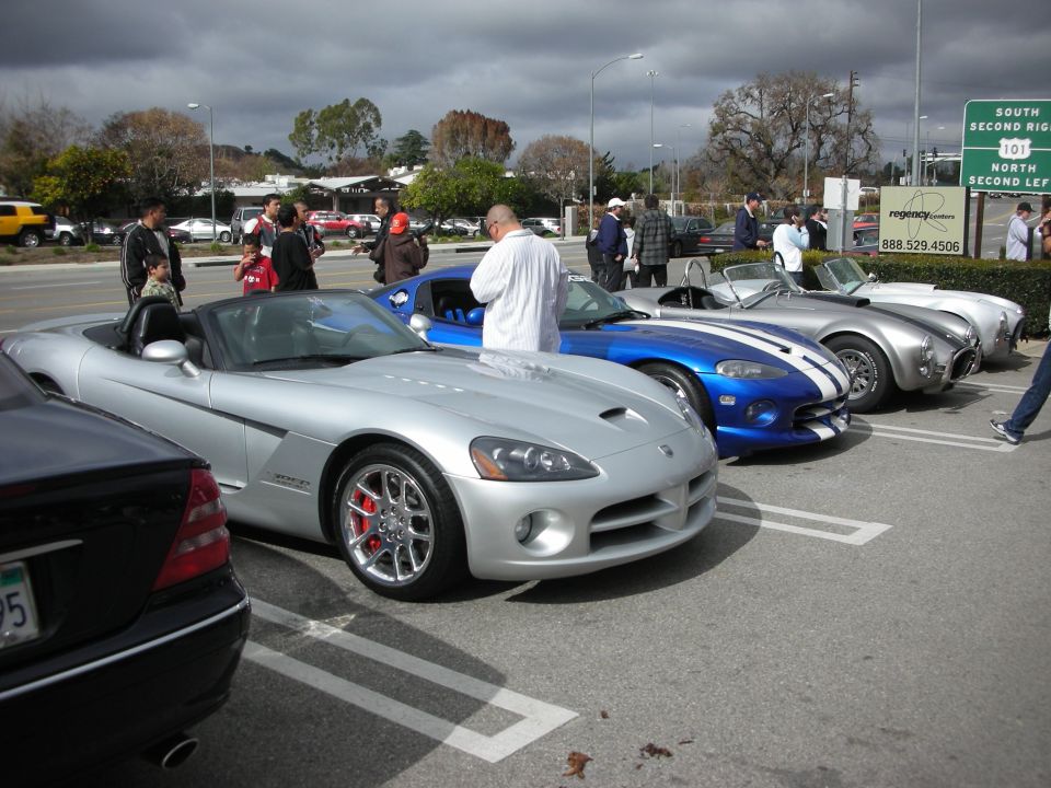 Silver Dodge Viper and blue Viper with white stripes parked in a row at a car show