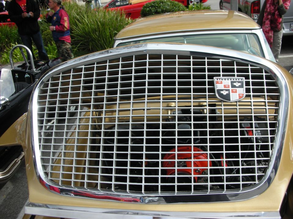 Chrome grille of a gold Studebaker with crest emblem