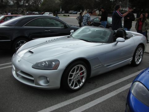 1998 Ford Crown Victoria - silver Dodge Viper roadster with the top down sits in a parking lot among other cars and onlookers at a car show.