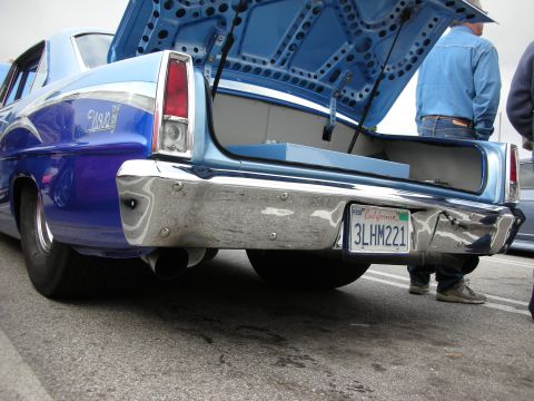 1998 Ford Crown Victoria - Rear view of a blue Chevy Nova with trunk open and a California plate reading 3LHM221 at a car show.