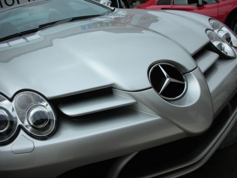 1998 Ford Crown Victoria - Close-up of the nose of a silver Mercedes-Benz SLR McLaren showing twin headlights and a large grille emblem.
