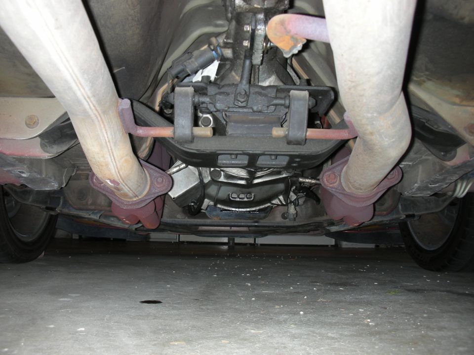 Underside rear view of a vehicle showing transmission crossmember, dual exhaust and rear axle