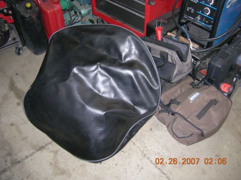 1996 Ford Bronco - A black vinyl seat cover is shown on the floor with various tools and equipment in the background.