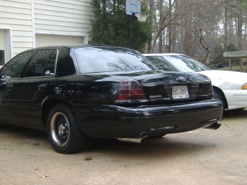 2001 Ford Crown Victoria - Rear quarter view of a black 2001 Ford Crown Victoria, parked next to a white sedan. The license plate reads AAD-4891.