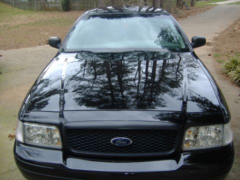 2001 Ford Crown Victoria - Front view of a black 2001 Ford Crown Victoria parked on a driveway.