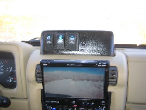 1996 Ford Bronco - Interior view of a vehicle's dashboard, showing aftermarket switches and a multimedia receiver.