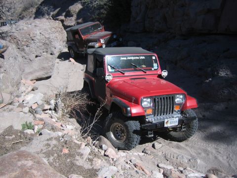1996 Ford Bronco - Two Jeeps navigate a challenging, rocky off-road trail.