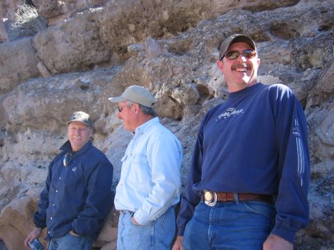 1996 Ford Bronco - Three men are gathered outdoors, standing against a large rock formation under a bright sky.