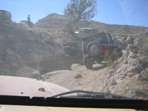 1996 Ford Bronco - Off-road vehicles navigate a challenging, rocky terrain under a clear blue sky.