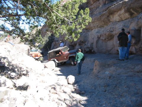 1996 Ford Bronco - Off-roading adventure on a challenging trail with multiple vehicles and onlookers.