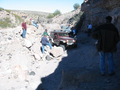 1996 Ford Bronco - Off-roading adventure in a canyon with multiple Jeeps on a challenging trail.