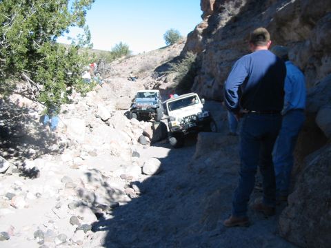 1996 Ford Bronco - Off-roading scene with two Jeeps navigating a difficult rocky path.