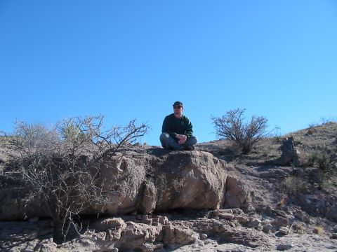 1996 Ford Bronco - A person enjoys a moment of rest on a rock formation in a desert environment.