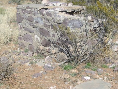 1996 Ford Bronco - A stone structure sits in a dry, brush-filled landscape under a clear sky.