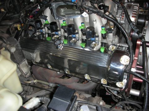1992 Ford Crown Victoria - Close-up view of engine components, including a chrome valve cover and fuel injectors.