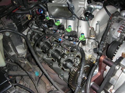 1992 Ford Crown Victoria - Close-up view of an engine, highlighting the camshafts, fuel injectors, and timing chain mechanism.