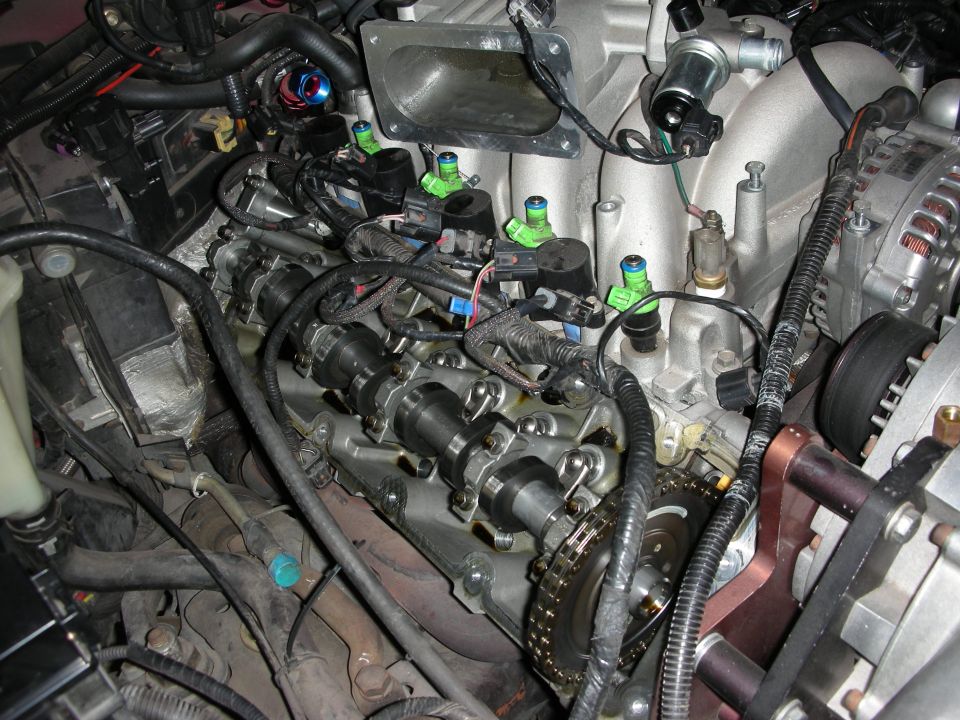 Engine with visible camshafts, fuel injectors, and timing chain