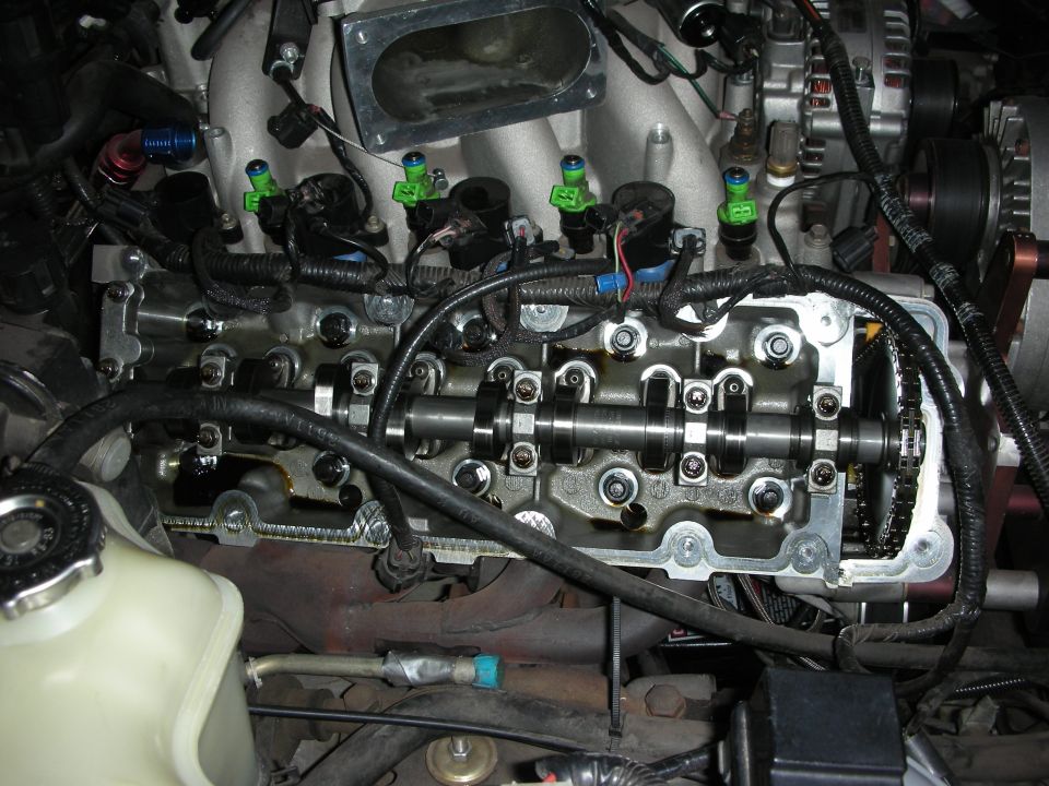 Close-up of an engine's overhead cam setup with fuel injectors visible