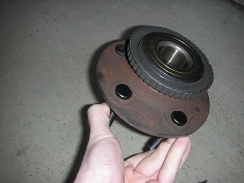 1992 Ford Crown Victoria - A close-up view of a wheel hub assembly, likely for a vehicle, held by a hand.