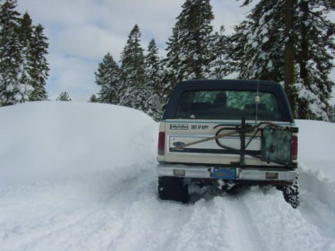 1986 Ford Bronco - Ford Bronco driving through deep snow with a Jerry can mounted on the rear carrier.
