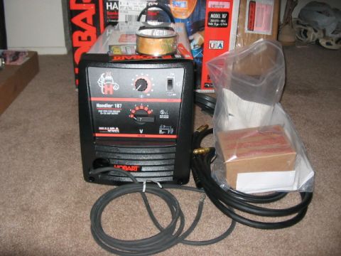 1991 Ford Bronco - A Hobart Handler 187 welder is shown with its accessories, including cables and a small box, placed on a carpeted floor.