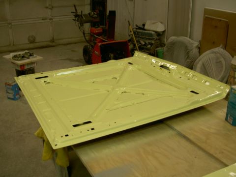 1967 Ford Ranchero - A yellow car hood is shown from the underside in a garage setting.