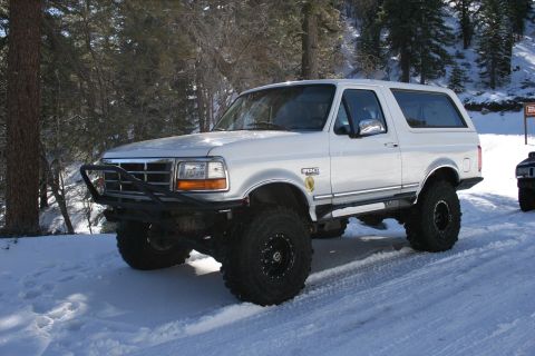 1996 Ford Bronco - White 1996 Ford Bronco modified for off-road use, seen in a snowy environment.