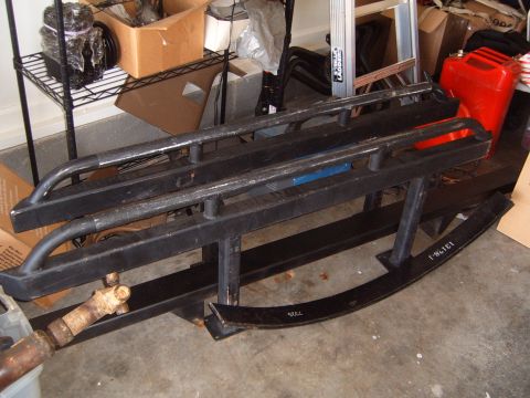 1988 Ford Bronco - Aftermarket off-road parts are stored in a garage next to a red jerry can and a ladder.