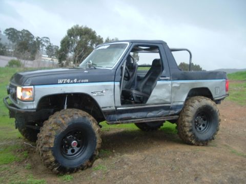 1989 Ford Bronco - This modified Ford Bronco features large off-road tires and a lifted suspension, with its doors removed.