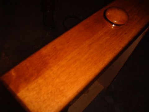 1988 Ford Bronco - A close-up view of a wooden furniture component, possibly a drawer front or cabinet door, with a circular knob attached.