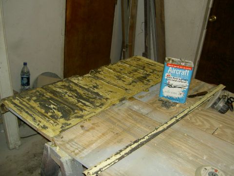 1967 Ford Ranchero - Car part with peeling paint and a can of paint stripper on a workbench.