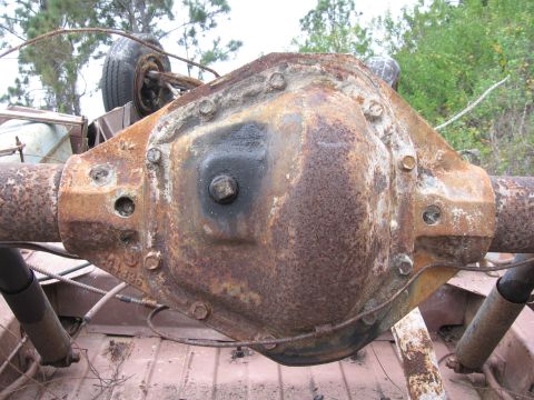 1974 Ford F-100 - Close-up of a heavily rusted rear axle differential housing, likely from an older truck.
