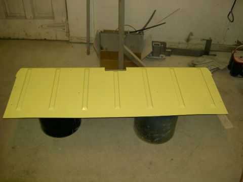 1967 Ford Ranchero - A yellow tailgate is shown, resting on two barrels in a workshop setting.