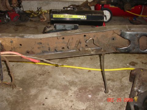 1978 Ford Bronco - Rusted vehicle frame section with attached wiring, Reddy Heater, and air compressor visible in background.