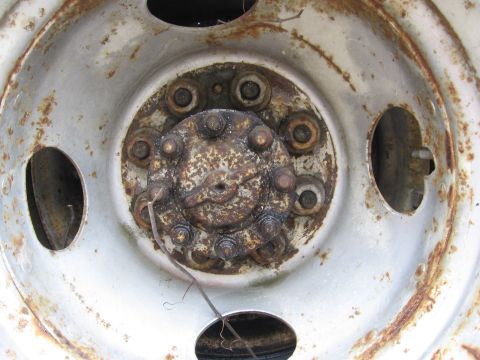 1974 Ford F-100 - This close-up shows a heavily rusted wheel hub with visible lug nuts and a central cap.