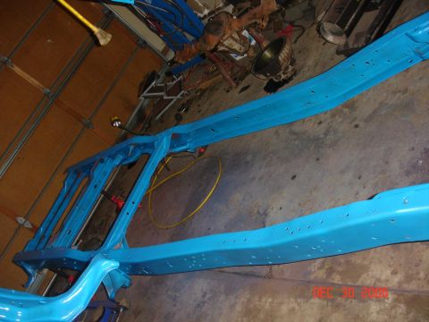 1978 Ford Bronco - Vehicle frame painted bright blue, undergoing restoration work in a garage setting.