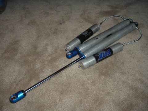 1989 Ford Bronco - Two Fox shock absorbers are shown with visible branding and blue accents.