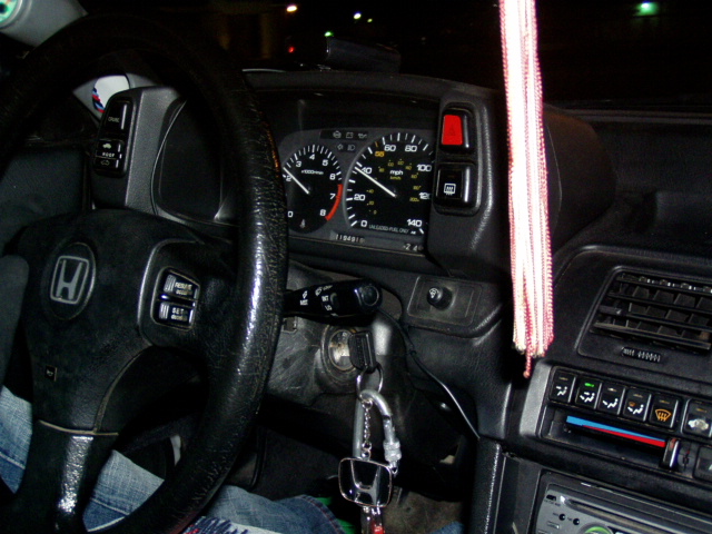 Interior view of a Honda with a steering wheel and dashboard gauges