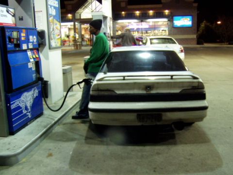 1993 Ford Probe - A white 1993 Ford Probe is being refueled at a gas station, with another car visible in the background.