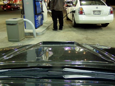 1993 Ford Probe - A car is being refueled at a gas station, with another car visible in the background.
