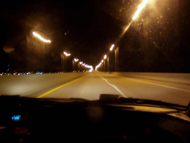 View from car interior looking out at a highway at night with streetlights