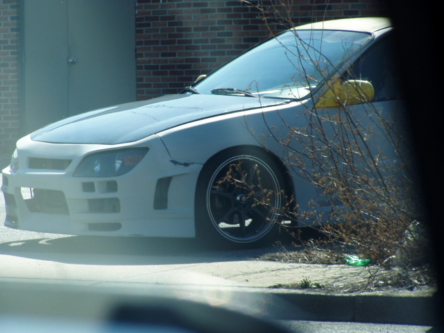 Modified front end of a car with yellow side mirror