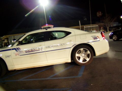 1993 Ford Probe - A Dorchester County Sheriff's patrol car is parked in a lot at night under a bright light.
