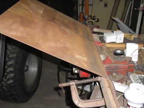 1966 Ford Bronco - Sheet metal is being worked on in a vise, with a tire and part of a vehicle visible in the background.