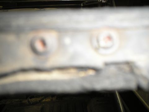 1966 Ford Bronco - This image shows a close-up view of two rusted bolts on a metal component, with a website watermark visible.