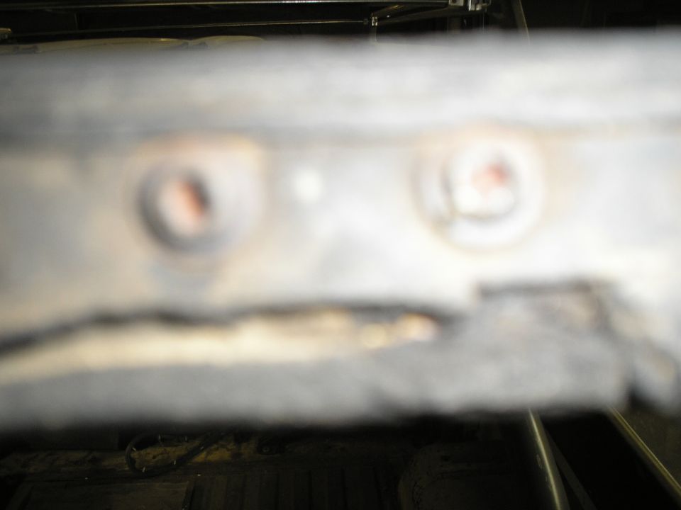 close-up of two rusted bolts on a metal surface, with a watermark for Supermotors.net at the bottom right