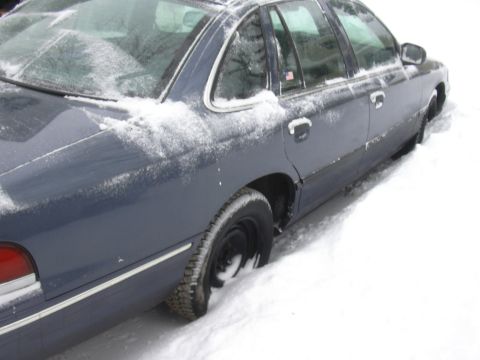 1996 Ford Crown Victoria - A 1996 Ford Crown Victoria is seen stuck in the snow, viewed from the side.