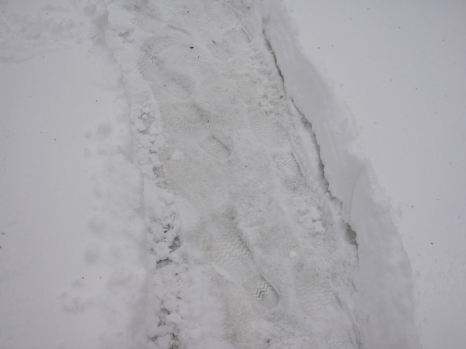 tire tracks and footprints in snow, with a watermark for Supermotors.net