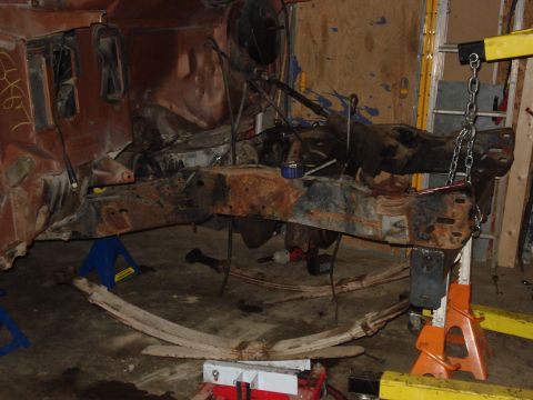 1989 Ford Bronco - The vehicle's chassis and suspension components are heavily rusted and appear to be undergoing repair or restoration.