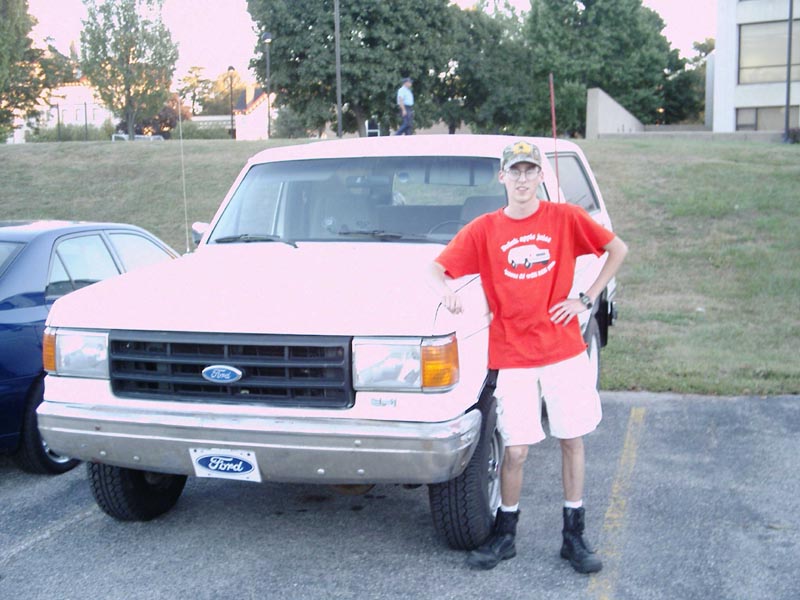 White Ford Bronco, front view, with a man standing next to it